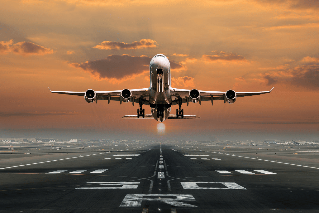 Passenger jet taking off from a runway at sunset