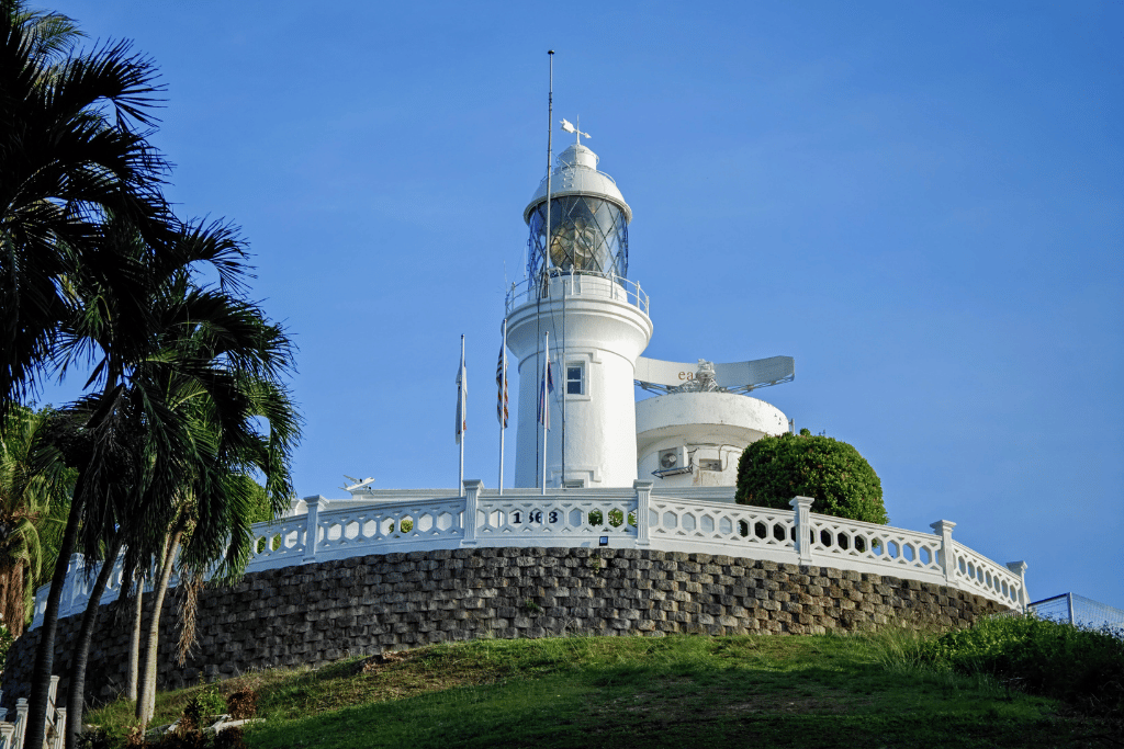 White Cape Rachado lighthouse on a palm-fringed hilltop in Port Dickson
