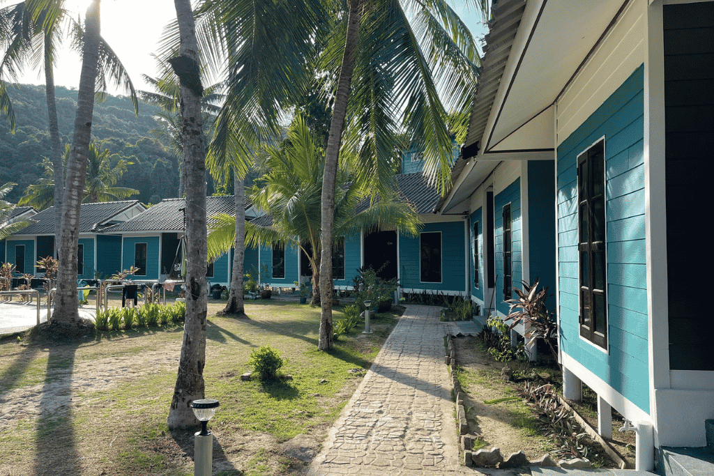 Row of teal-trimmed beach chalets among palm trees on Redang Island