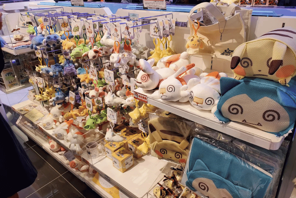 Display counter packed with Pokémon plush toys and merchandise, including a large blue character pouch