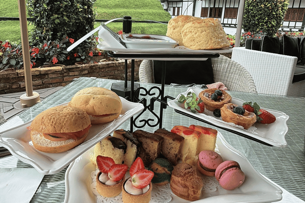 Scones, pastries and cakes on a tiered stand at an outdoor table in Cameron Highlands