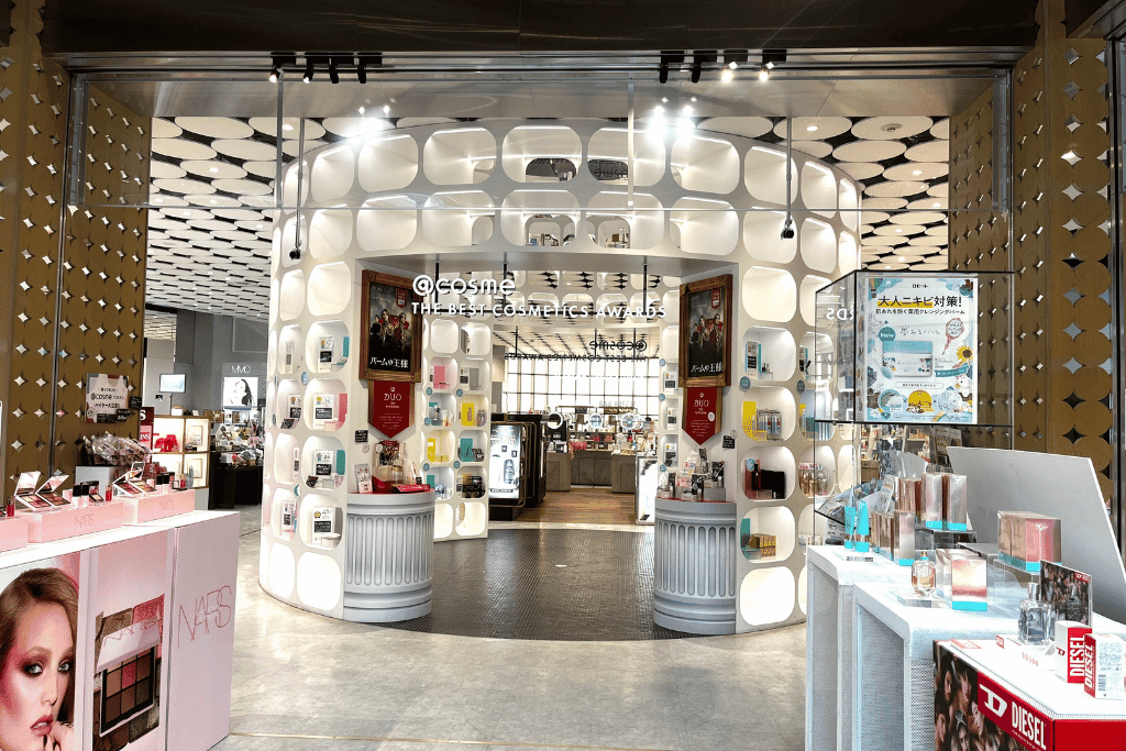 Bright interior of @cosme TOKYO's ground floor with circular product display pillars