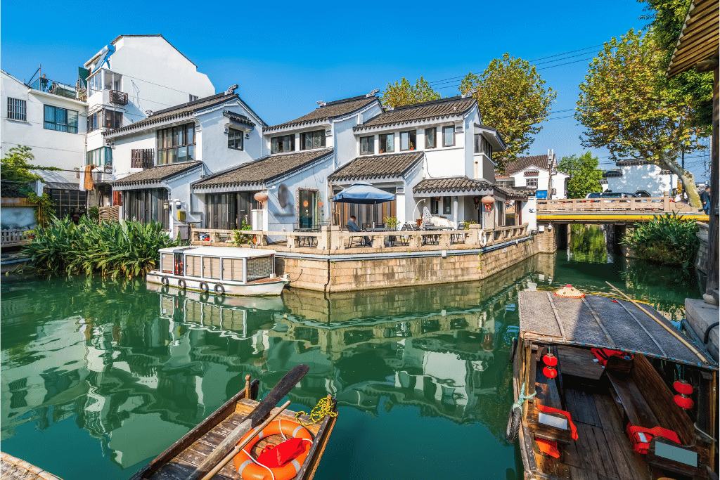 White canal-side houses and moored boats along Suzhou's Pingjiang Road