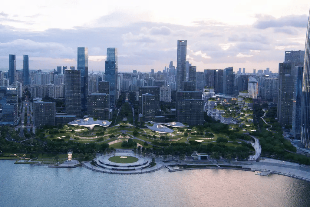 Aerial view of green-roofed Shenzhen Bay Park along the waterfront with the city behind
