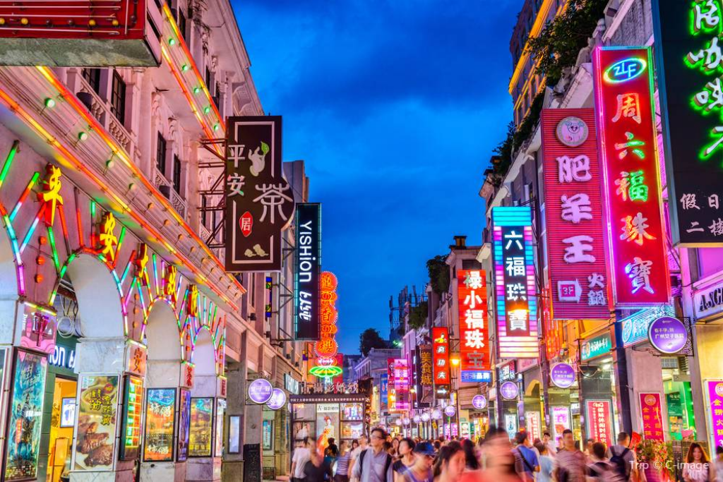 Crowded neon-lit pedestrian shopping street glowing at night
