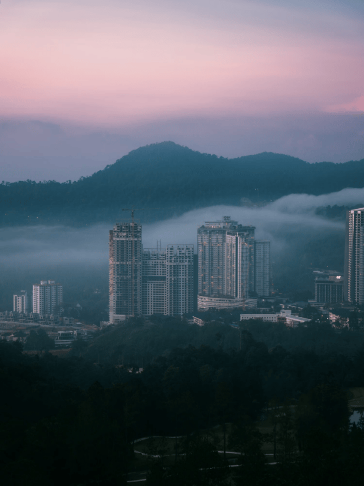 Genting Highlands hotel towers wrapped in low cloud at dusk