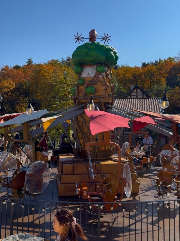 The flying-machine ride with pink wings in the Valley of Witches at Ghibli Park