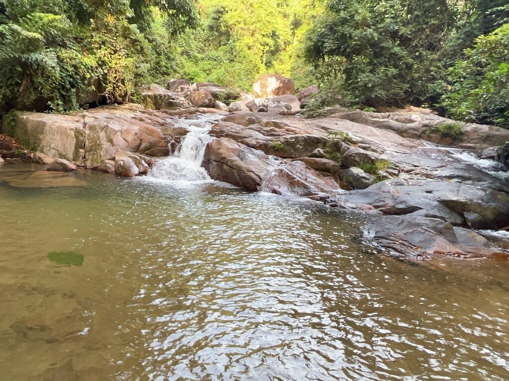 A calm rock pool below a small cascade in the jungle at Lubuk Teja, Juara