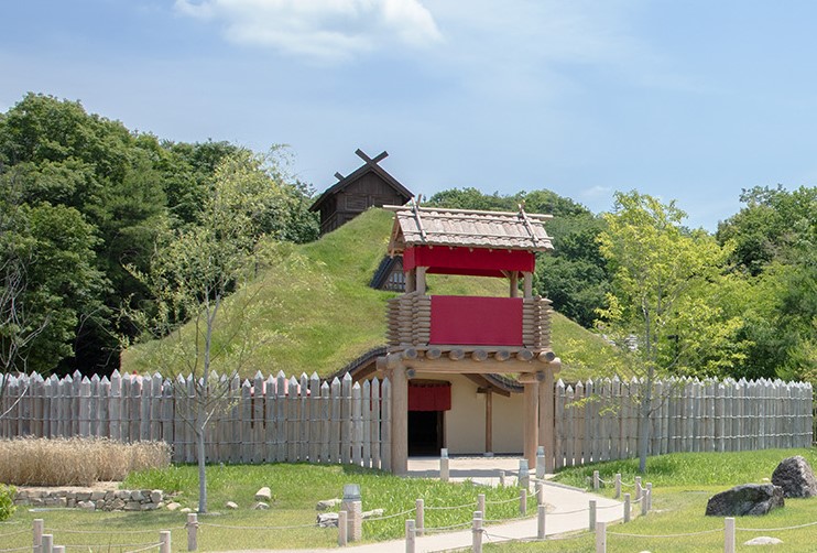 Grass-roofed gate and wooden palisade fence of Mononoke Village at Ghibli Park