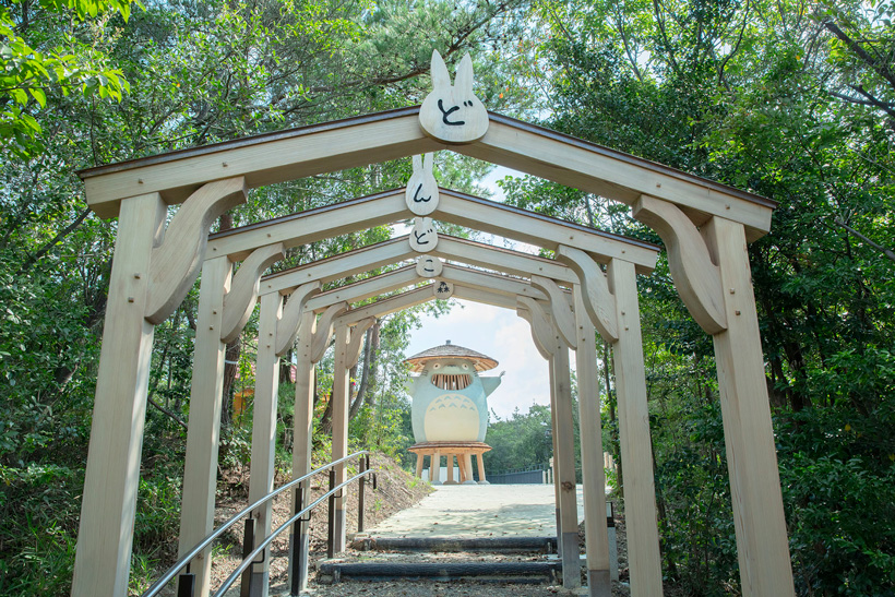 Covered wooden archway path leading up to the Dondoko-do play structure in Dondoko Forest