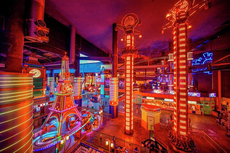 Neon-lit rides and tower attractions inside Skytropolis Funland indoor park