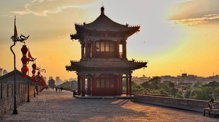 A watchtower pavilion on the Xi'an City Wall at sunset, lined with red lanterns