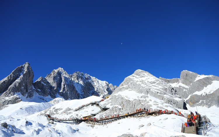 Snow-capped peaks and a boardwalk crowded with visitors at Jade Dragon Snow Mountain