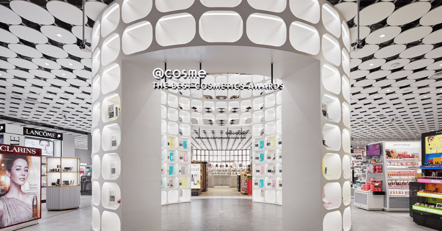 The curved white entrance and globe-lit ceiling inside @cosme TOKYO in Harajuku