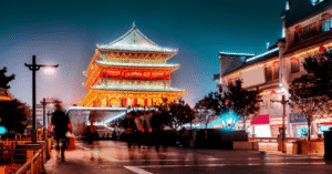 Xi'an's Drum Tower illuminated gold at night above a busy city street