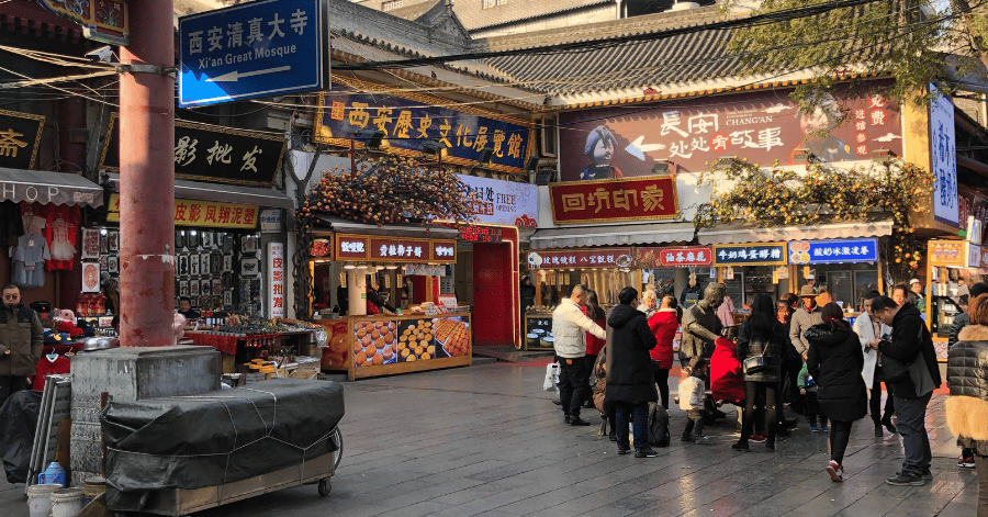 Food stalls and crowds along a street in Xi'an's Muslim Quarter