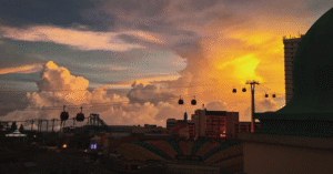 Cable cars and Genting Highlands resorts silhouetted against a vivid sunset sky