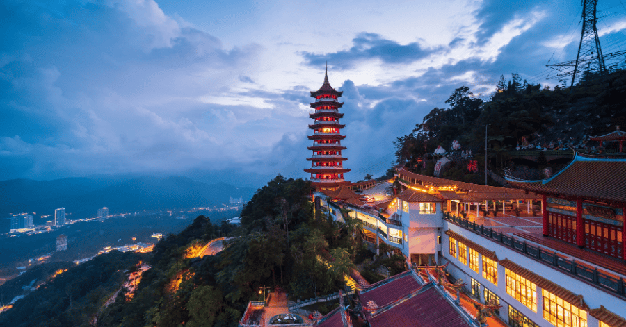 Chin Swee Caves Temple's nine-storey pagoda lit at dusk on the mountainside