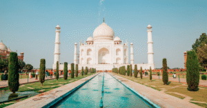 The Taj Mahal and its reflecting pool under a clear blue sky in Agra, India