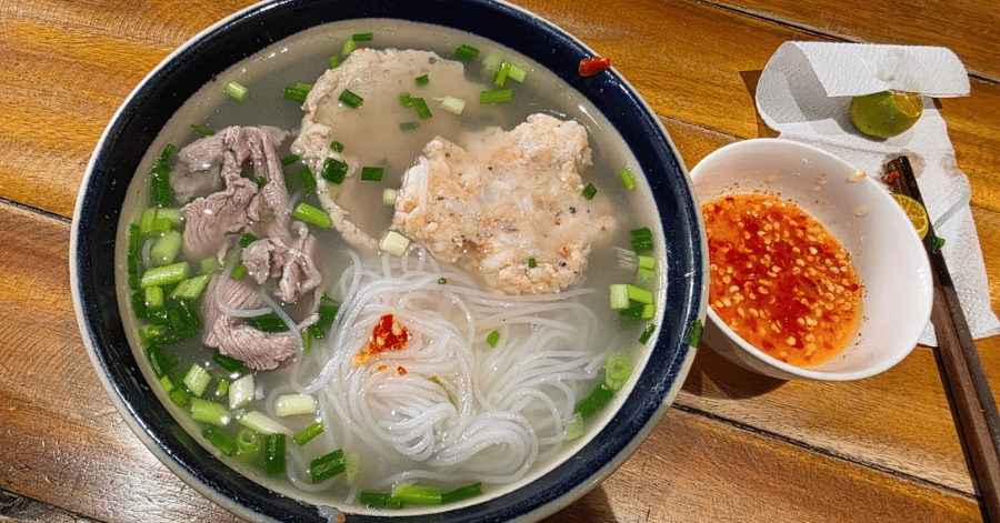 Bowl of bun quay seafood rice-vermicelli noodles with a red chilli dipping sauce