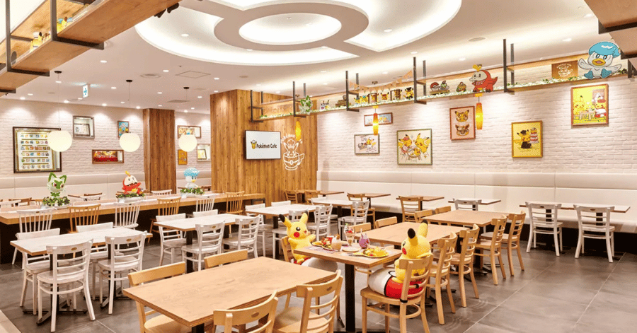 Wood-themed Pokémon Café dining room with light timber tables and chairs and framed character art on the walls
