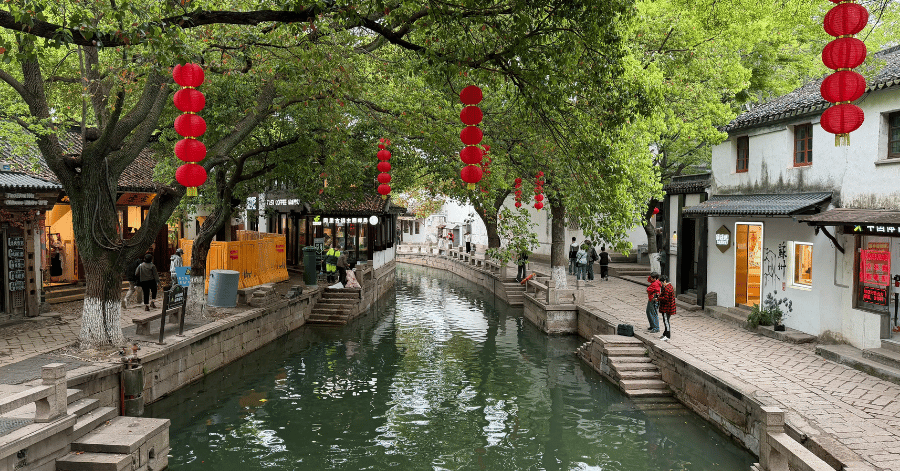 A Tongli canal lined with red lanterns, shops and strolling visitors