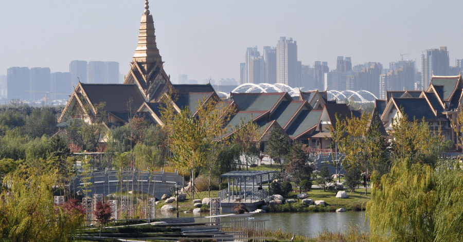 A lakeside park with traditional pavilions and Xi'an's modern skyline behind
