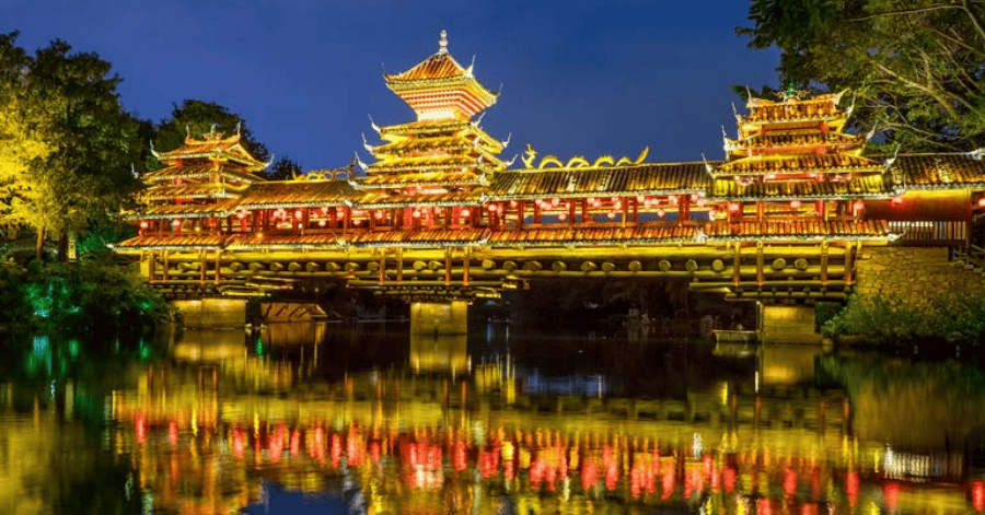 Illuminated traditional Chinese pavilion reflected in water at Splendid China Folk Village