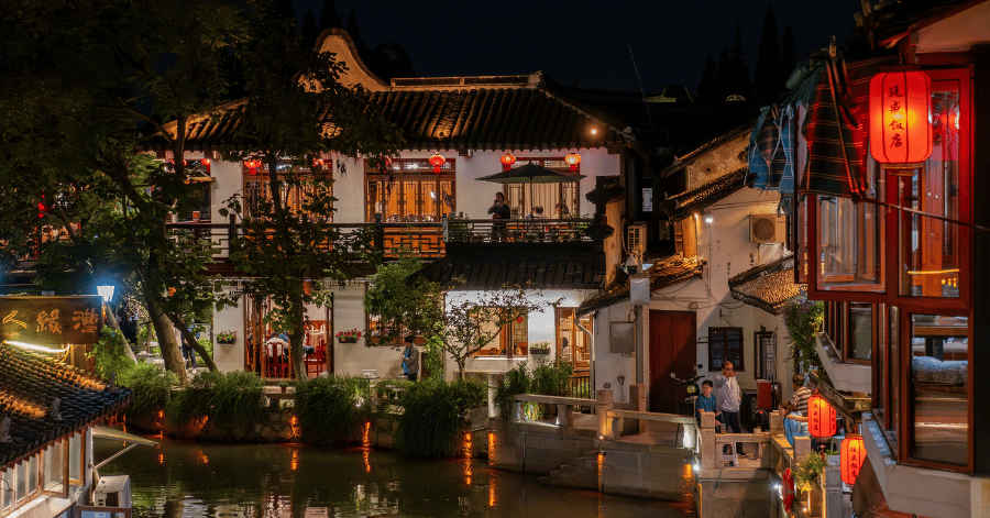 Lantern-lit traditional houses reflected in a Suzhou old-town canal at night
