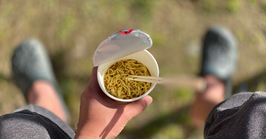 Hand holding a finished homemade cup noodle made at the museum