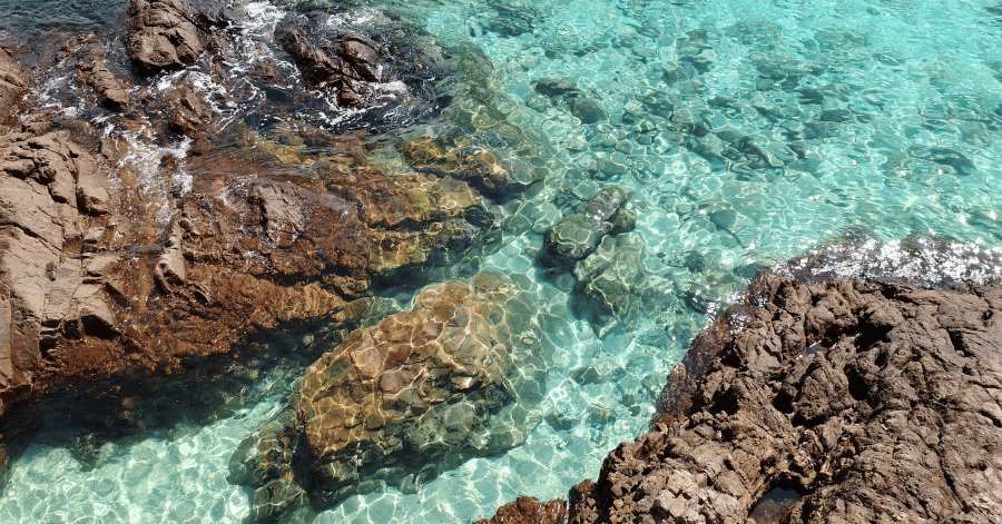 Clear turquoise water over rocky coral shallows at Redang Island