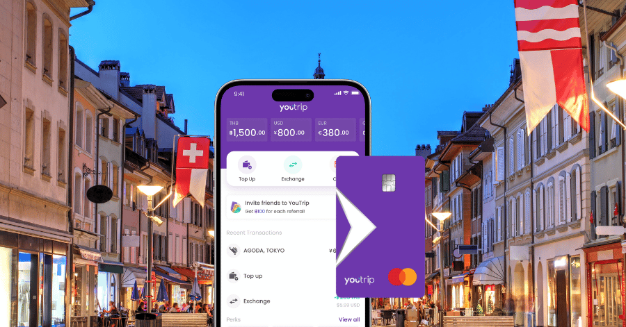 A hand holding a phone with the YouTrip app and a purple YouTrip card on a European street