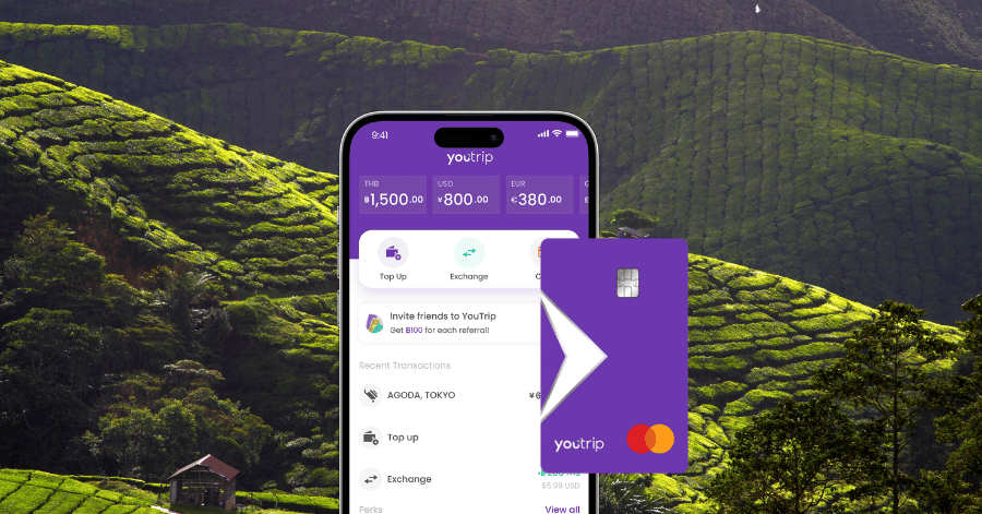 YouTrip app on a phone beside a purple YouTrip Mastercard against a tea-plantation backdrop