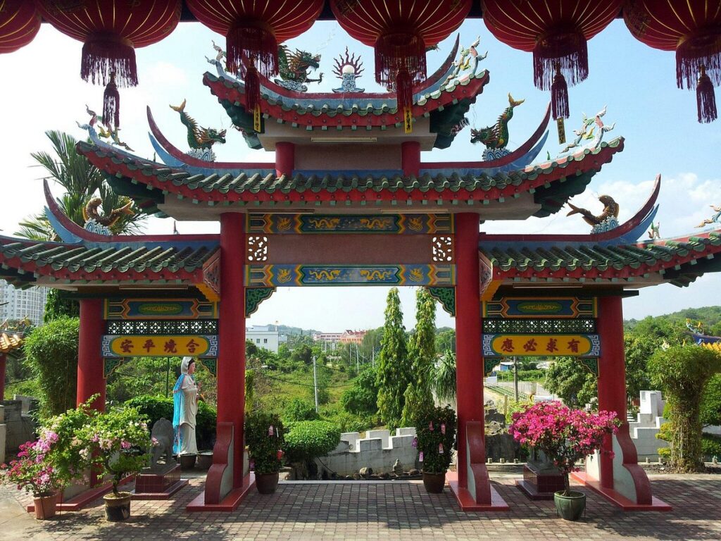 Ornate red Chinese temple gateway with dragon roof carvings at Wan Loong Temple
