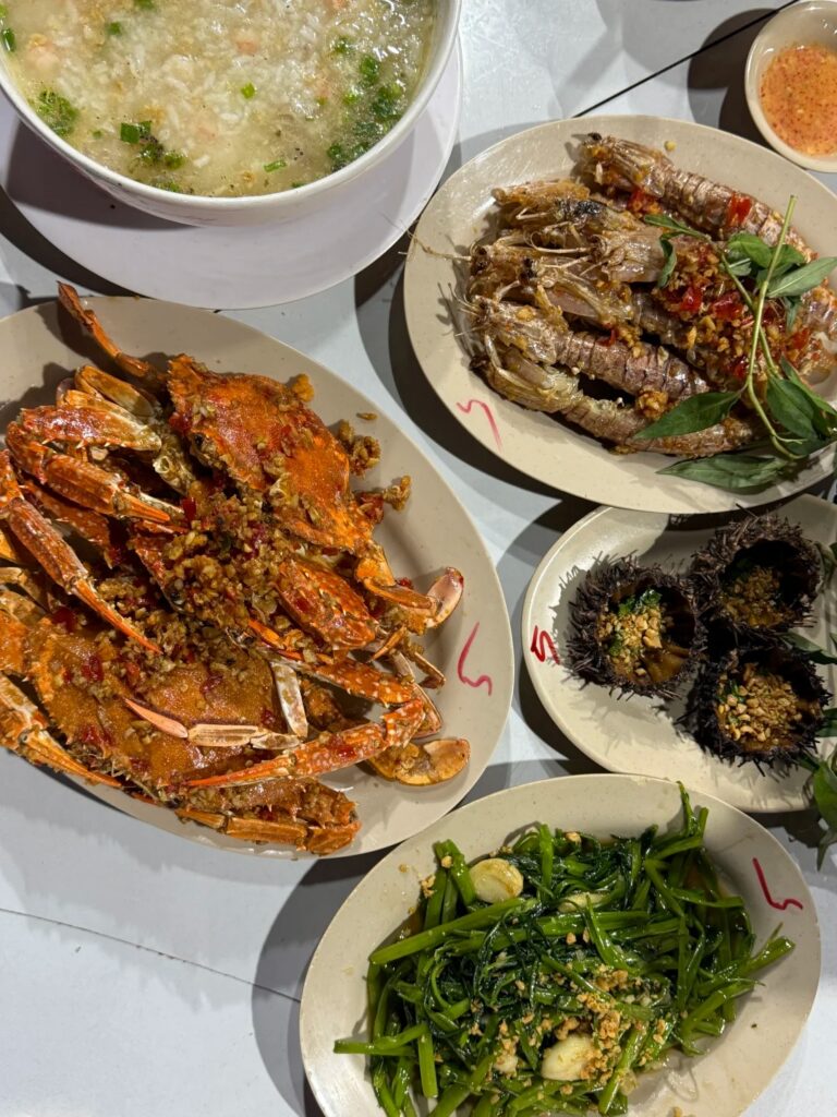 Spread of Vietnamese seafood including chilli crab, grilled prawns, sea urchin and greens