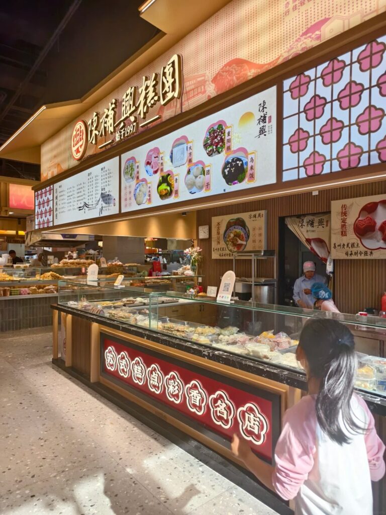 A traditional rice-cake and dumpling stall with a glass display at a Suzhou market