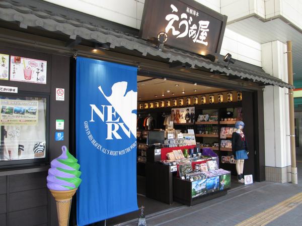 The EVA-YA Evangelion shopfront with a blue NERV banner and a Rei Ayanami figure