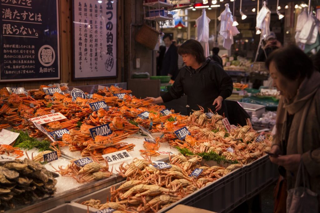 Snow crabs on ice with price tags at a seafood stall in Omicho Market, Kanazawa