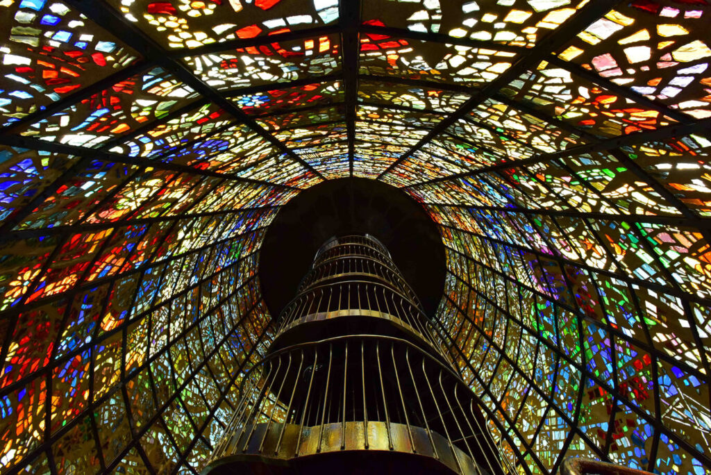 Looking up the spiral staircase inside the colourful stained-glass Symphonic Sculpture tower