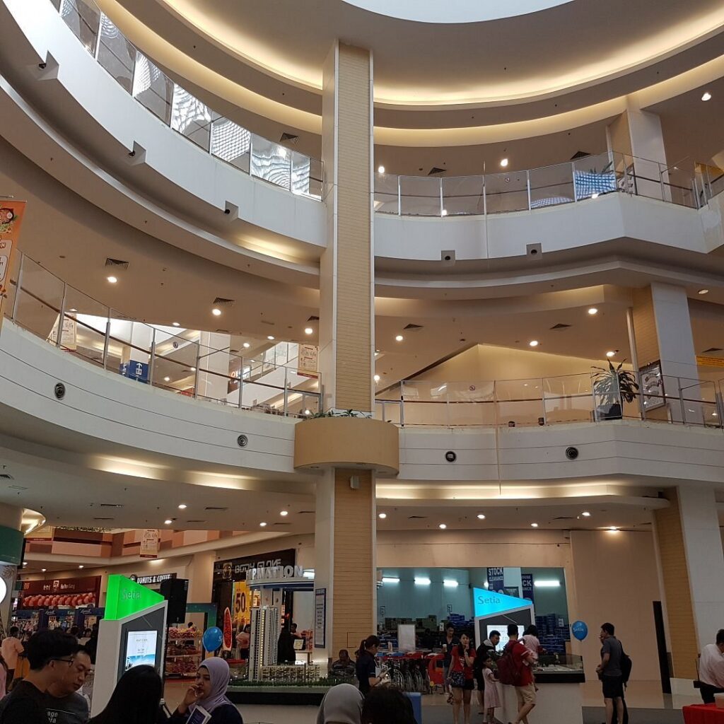 The multi-level central atrium of AEON Mall Bukit Indah with curved balconies and shoppers below