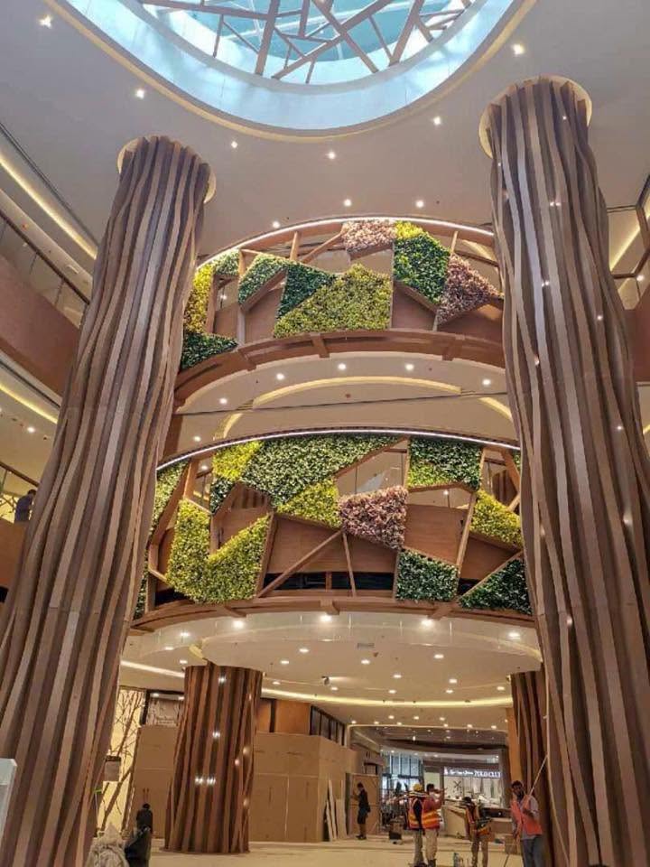R&F Mall's atrium with tall timber columns and a tiered green living-wall centrepiece under a skylight
