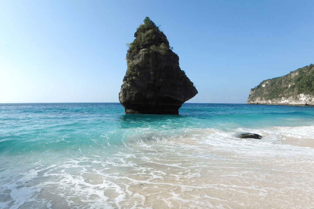 Suwehan Beach's distinctive pointed 'Love Rock' rising from turquoise shallows offshore