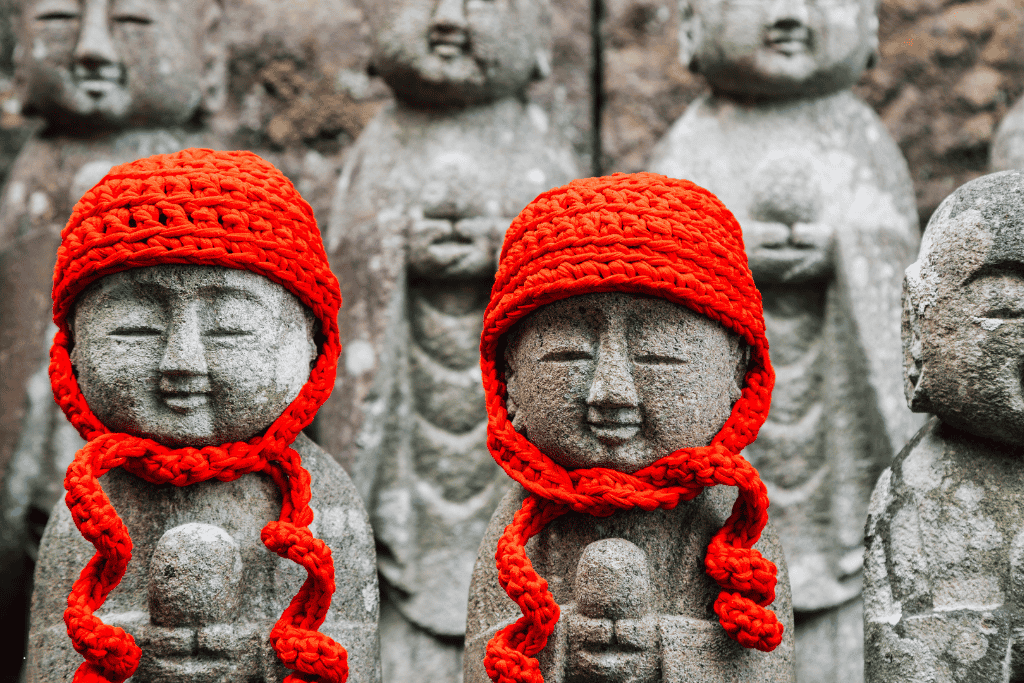 Small stone Jizo statues wearing red knitted caps at Hasedera temple, Kamakura