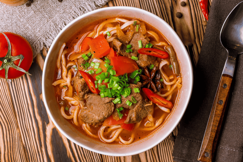 A bowl of lagman: hand-pulled noodles with beef, peppers and spring onion in broth