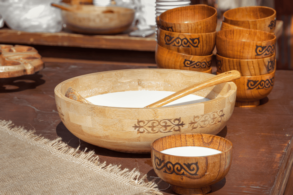 Wooden bowls of white fermented mare's or camel's milk with carved Kazakh cups