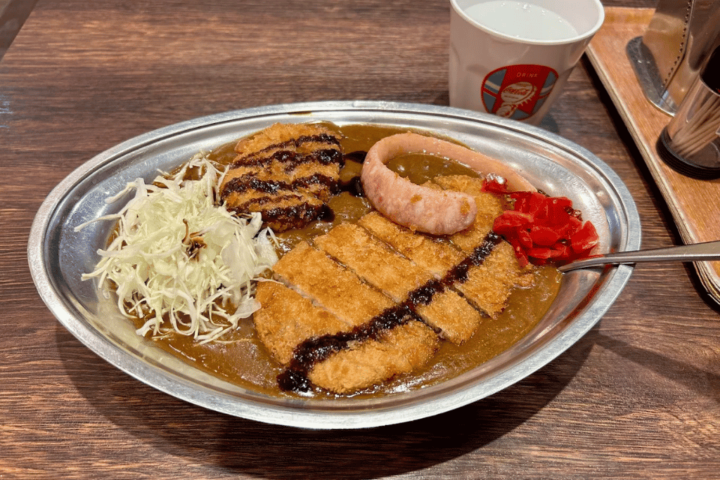 Kanazawa curry: dark roux with a breaded cutlet and shredded cabbage on a stainless plate