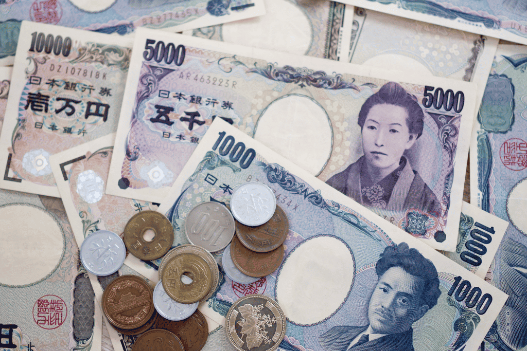 A pile of Japanese yen banknotes and coins in various denominations