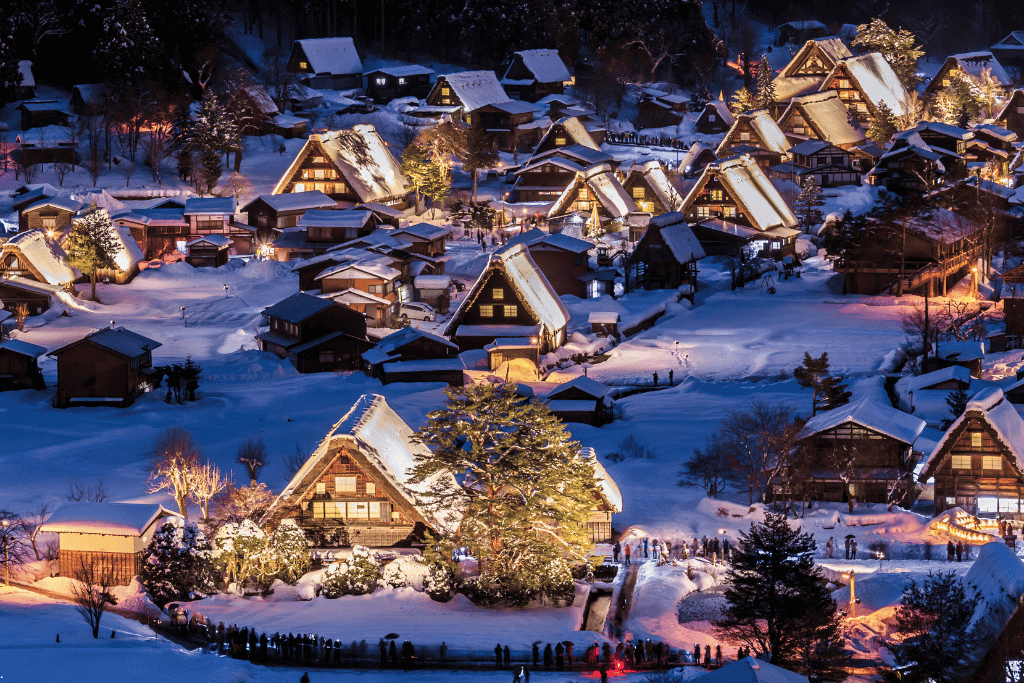 Aerial view of Shirakawago's snow-covered houses glowing during the winter light-up