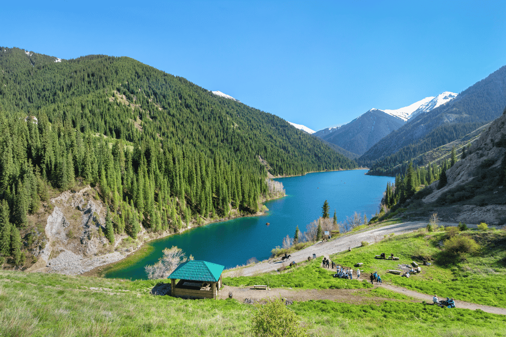 The emerald lower Kolsai Lake ringed by pine-forested slopes and peaks