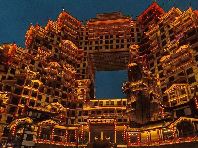 The illuminated tiered Tujia stilt-building complex of the 72 Strange Building at night